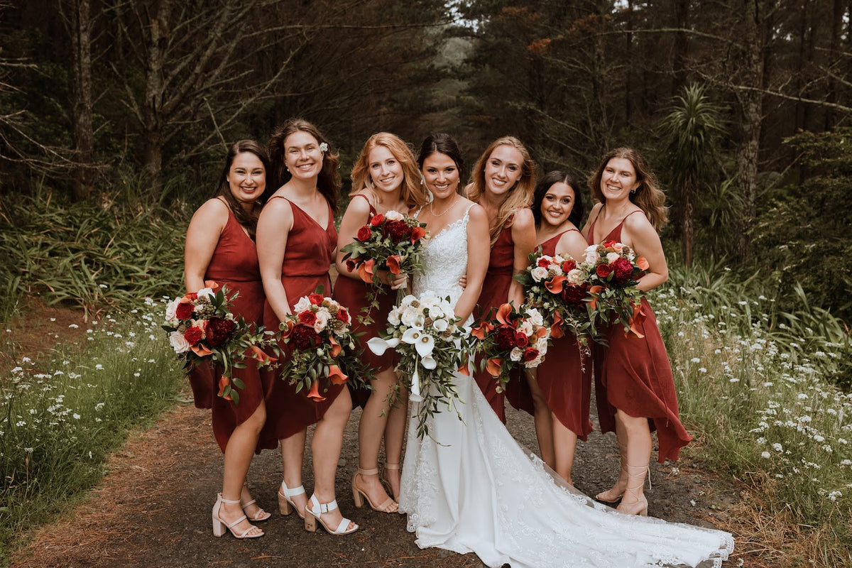 RED-WHITE-BRIDAL-PARTY-STANDING-IN-FOREST-HOLDING-BOUQUETS