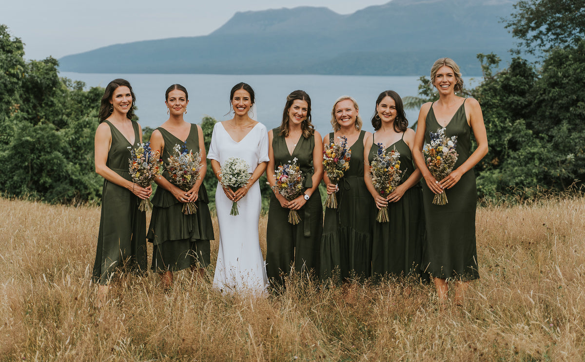 BRIDAL-PARTY-STANDING-TUSSOCK-GRASS-HOLDING-BOUQUETS