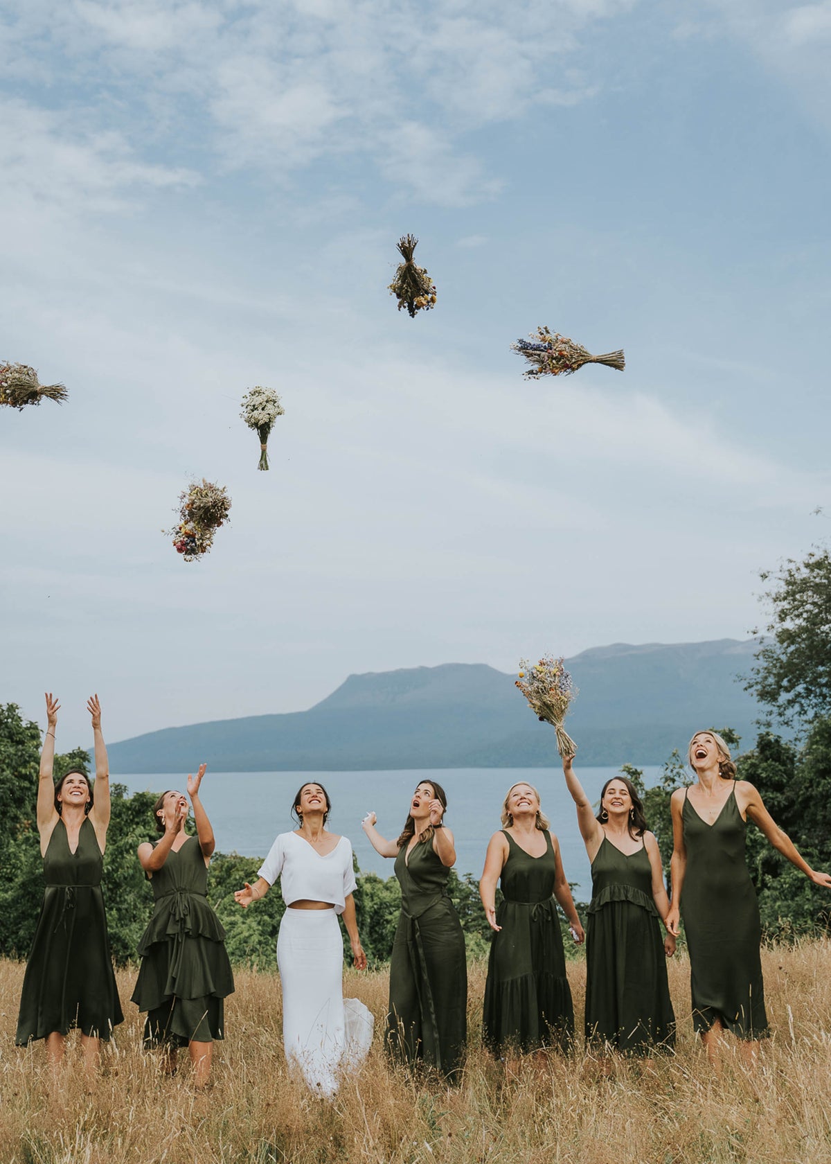BRIDAL-PARTY-THROWING-BOUQUETS-IN-TUSSOCK-GRASS