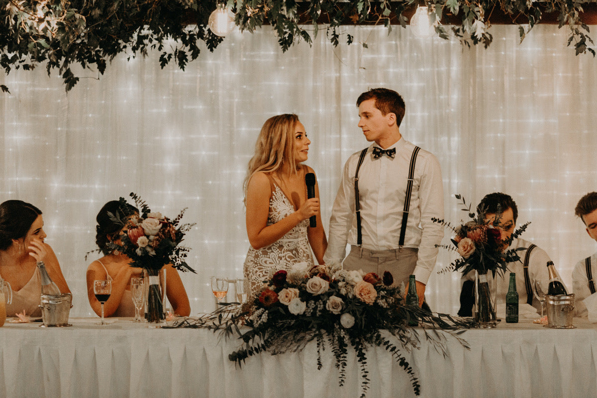 BRIDE-DOING-SPEECH-TO-GROOM-AT-BRIDAL-TABLE