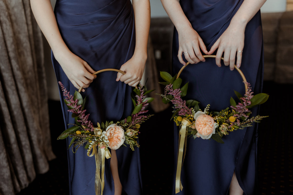 TWO-BRIDESMAIDS-HOLDING-FLOWER-WREATHS