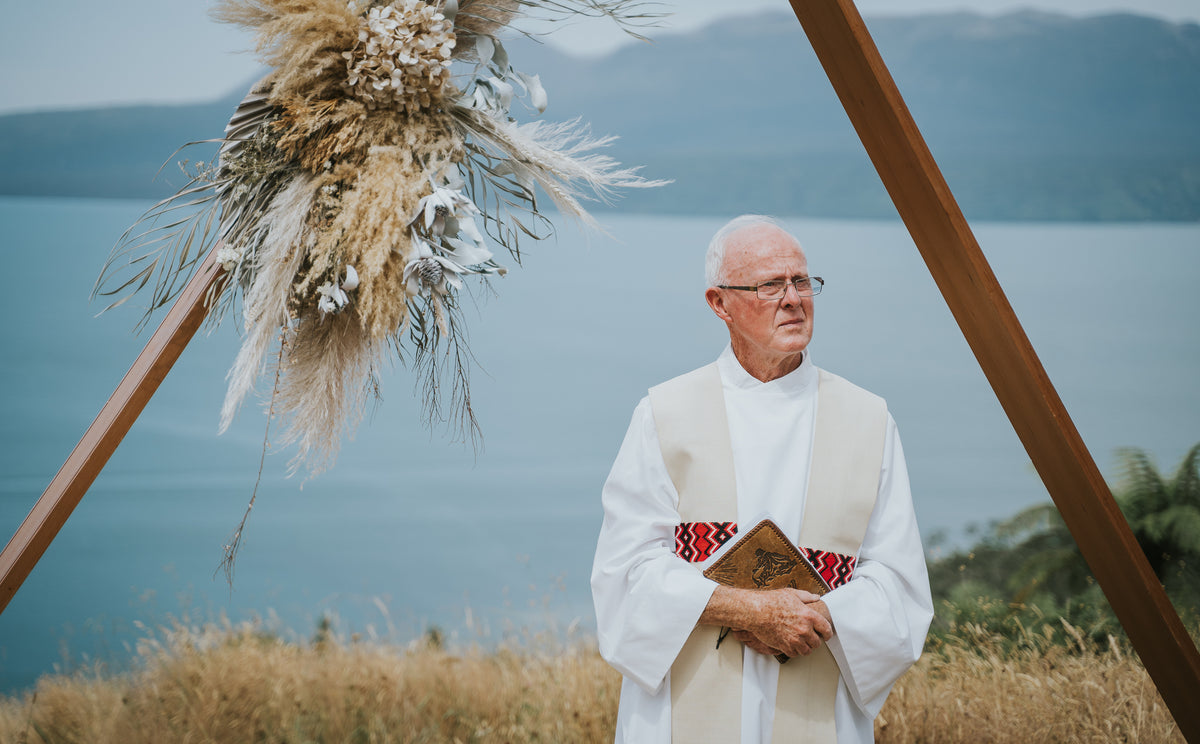 PRIEST-STANDING-AT-END-OF-AISLE-WITH-FLOWER-INSTALLATION