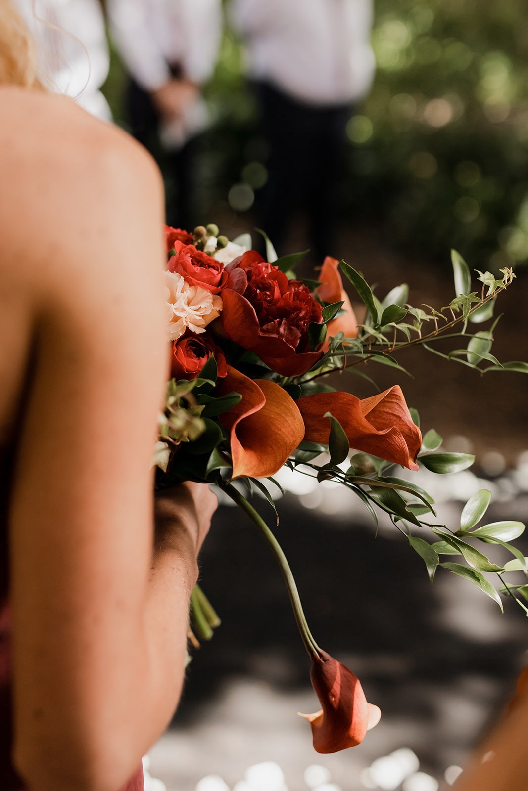 OVER-THE-SHOULDER-SHOT-OF-RED-BRIDESMAID-BOUQUET