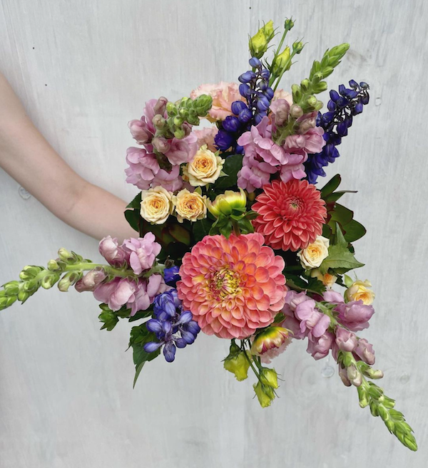 Botanics-bright-asymmetrical-flower-bouquet-being-held