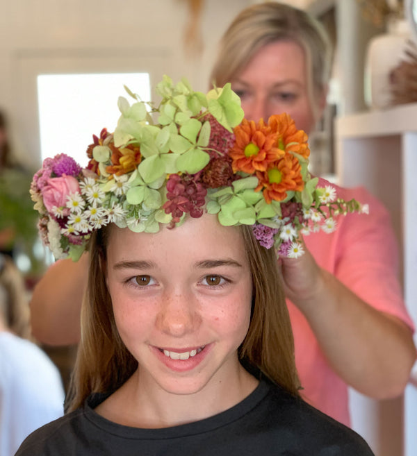Colourful flower crown on young female at flower workshop