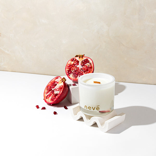 Neve white candle on stand with open pomegranate and seeds